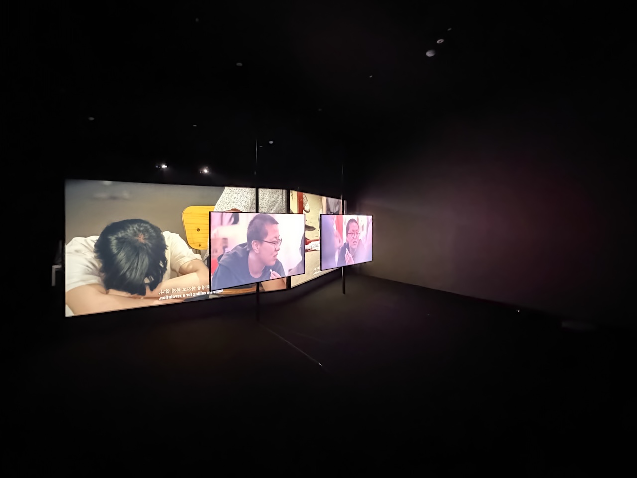 第4展示室の小部屋におけるワン・トゥオの展示風景。前のふたつのモニターで再生されている作品は《所有権と自立性の実験的パラダイム》（2026）。後ろ側のふたつのスクリーンで投影されている作品は《ラチェット・ドリル（Ratchet Drill）》（2026）。撮影：三嶋一路